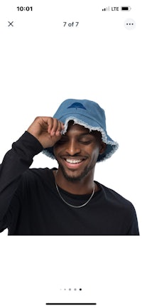 a man wearing a denim bucket hat with a smile on his face