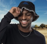 a man wearing a black bucket hat in a field